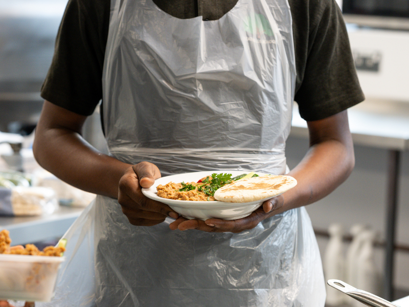 student proudly holding his ful medames